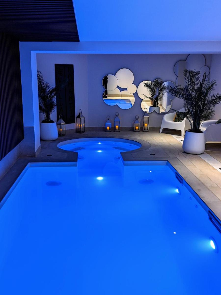 une grande piscine à la lumière bleue dans l'établissement Hotel Villa Romantic & Spa, à Paris