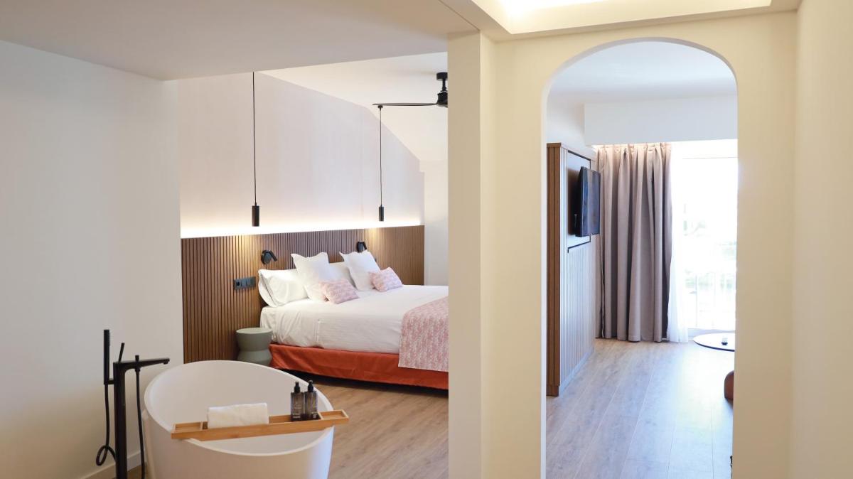 Una habitación de hotel con una cama y un televisor. en Seth Port Ciutadella, en Ciutadella