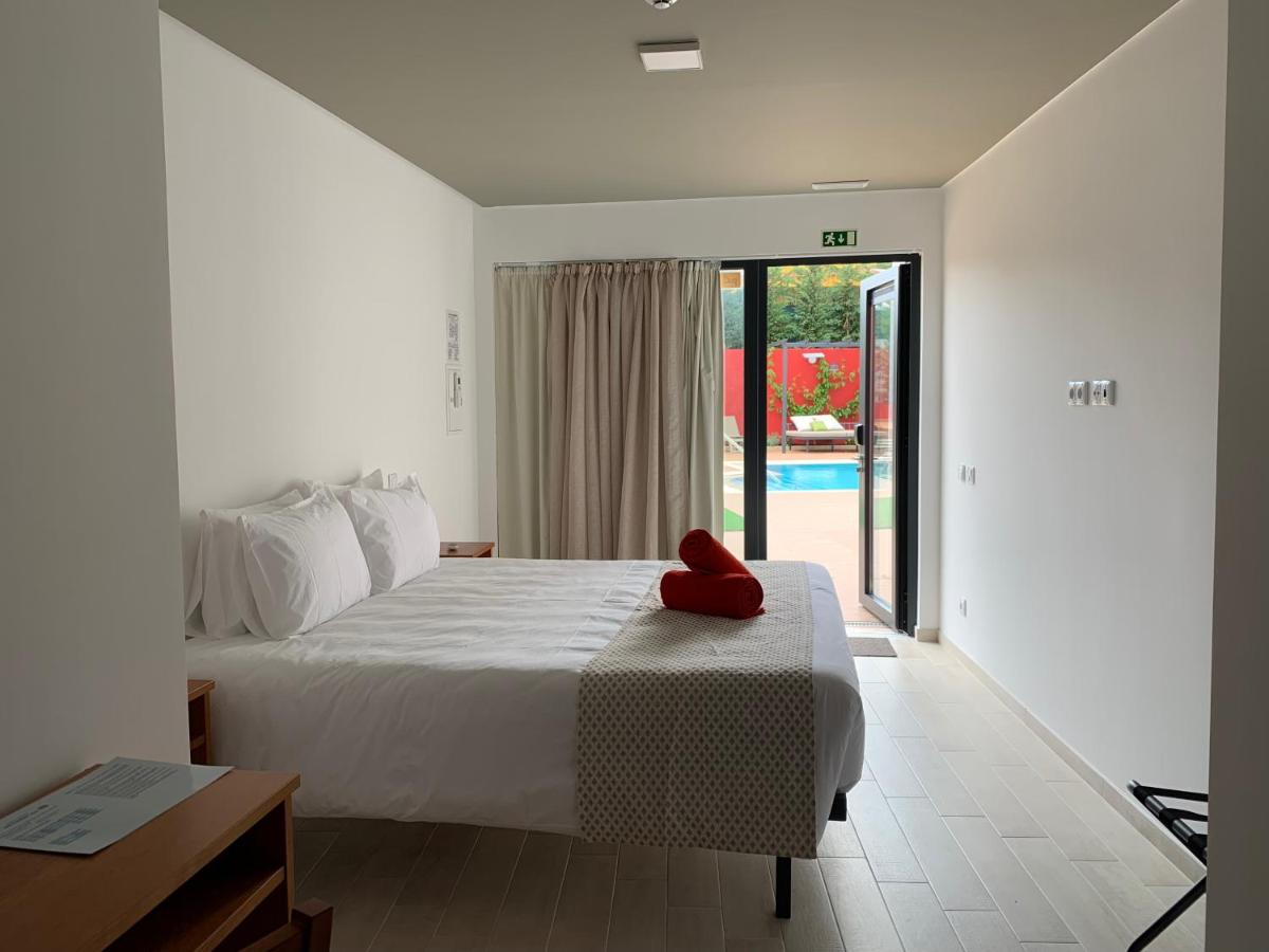 um quarto com uma cama com uma almofada vermelha em Villa 3 Caparica - Lisbon Gay Beach Resort em Charneca