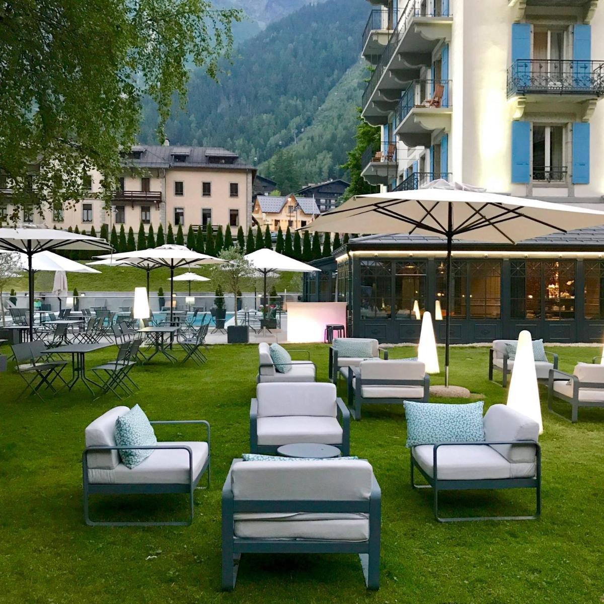un groupe de chaises longues et de parasols sur l'herbe dans l'établissement Hôtel Mont-Blanc Chamonix, à Chamonix-Mont-Blanc