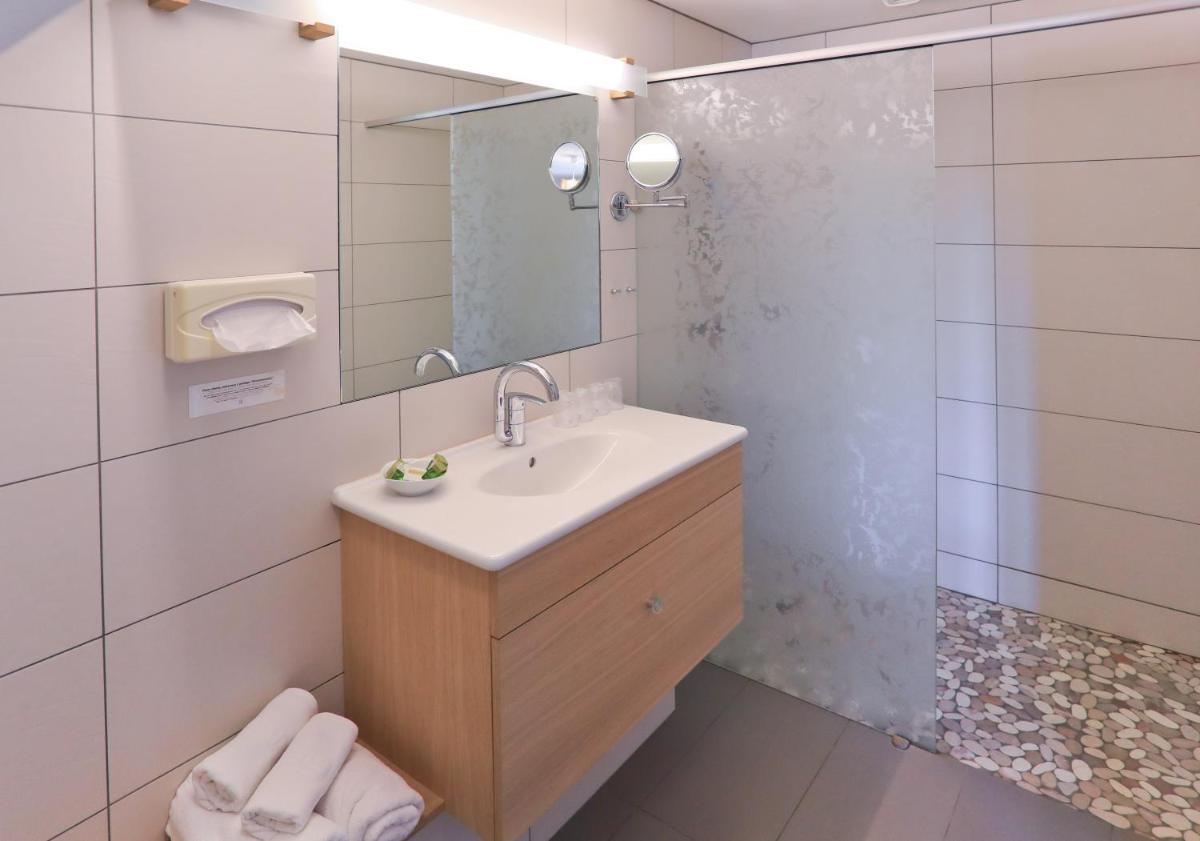 une salle de bain avec un lavabo et une douche dans l'établissement Logis Hôtel Restaurant & Spa les Remparts, à Salers