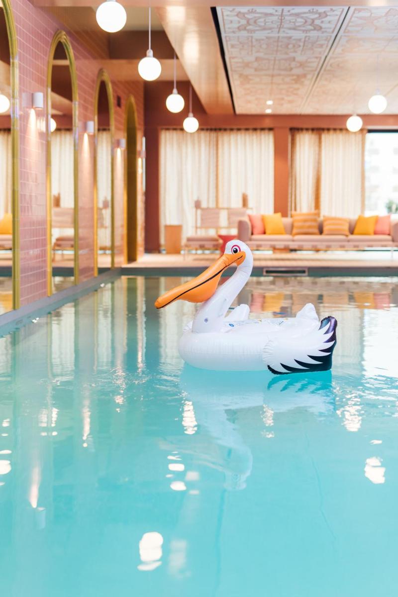 un cygne blanc flottant dans une piscine dans l'établissement Mama Shelter Rennes, à Rennes