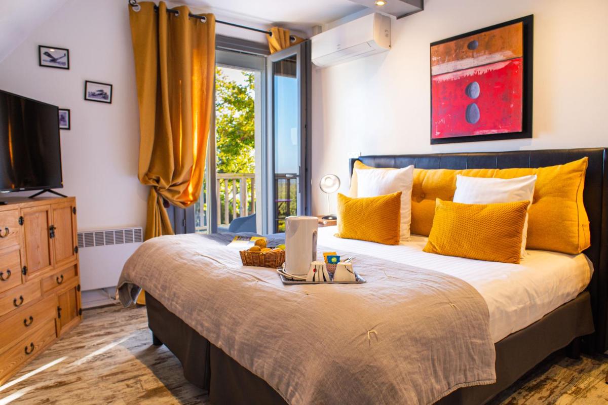 une chambre avec un lit avec un ordinateur portable dessus dans l'établissement Les Terrasses de Saumur - Hôtel & Appartements - Restaurant & Spa (Logis), à Saumur
