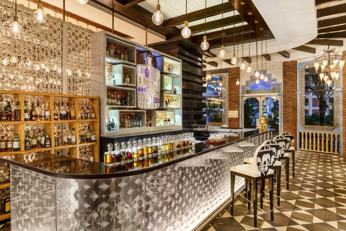 a bar with chairs and a counter with alcohol at Sofitel Mumbai BKC in Mumbai