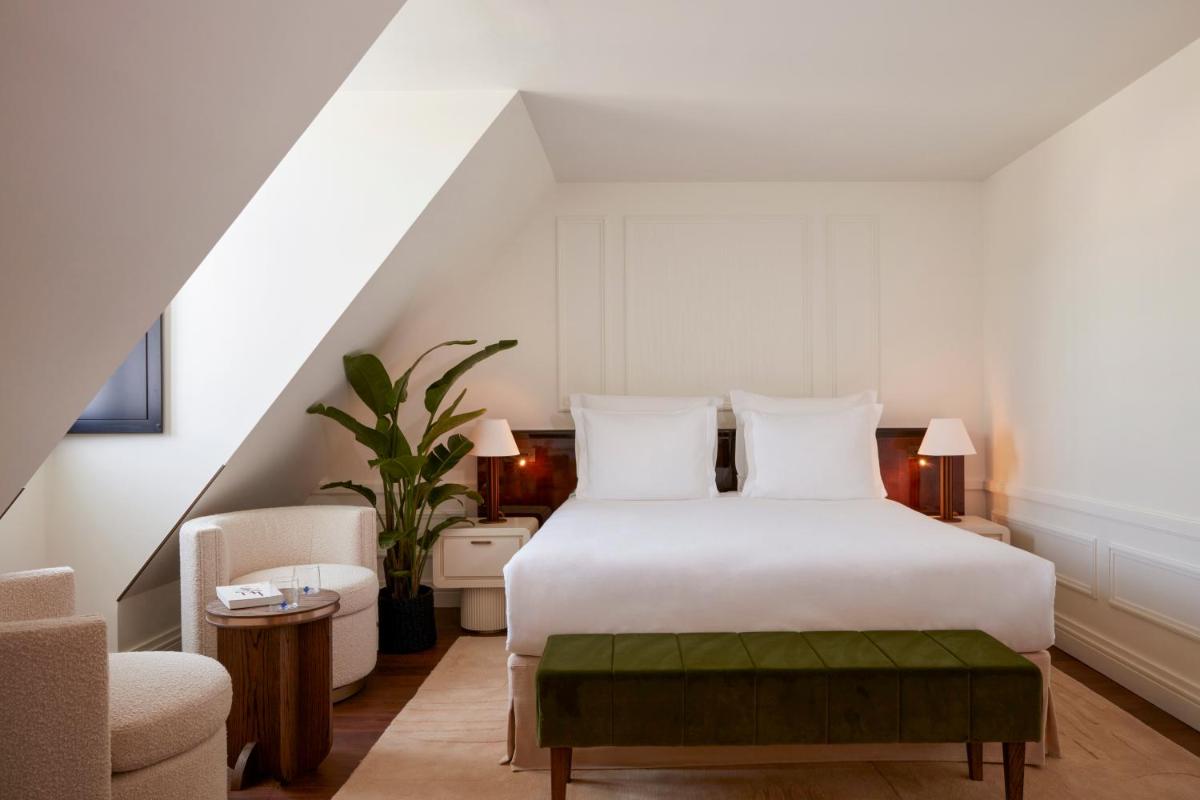 une chambre avec un lit blanc et une chaise dans l'établissement Maison Delano Paris, à Paris