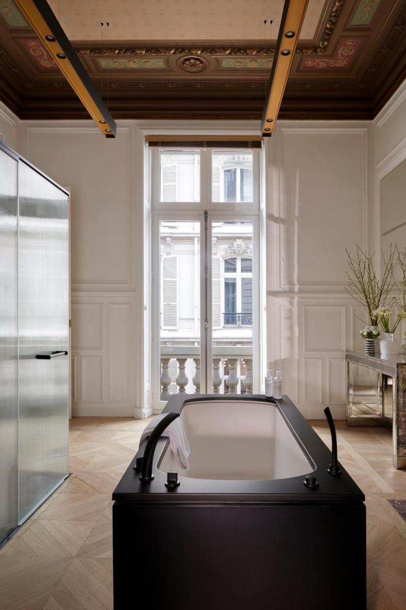 une baignoire dans une pièce avec une fenêtre dans l'établissement Maison Delano Paris, à Paris