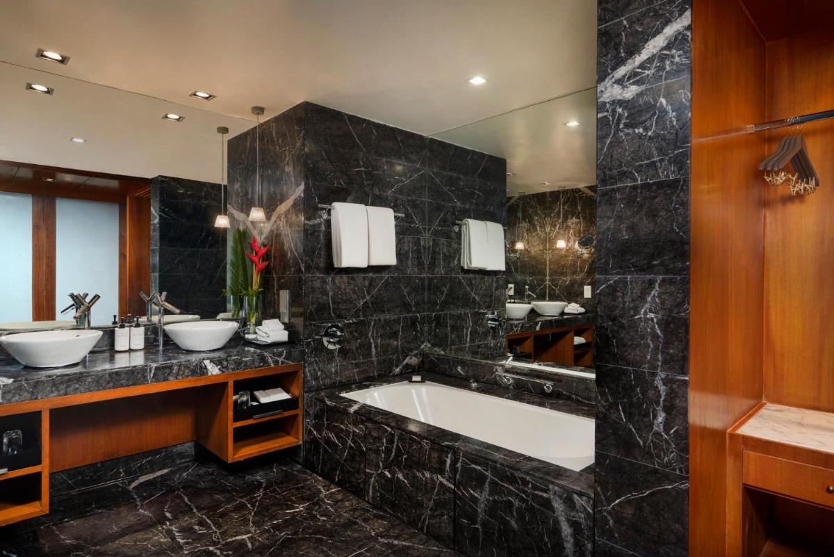 a bathroom with two sinks and a bath tub at InterContinental Marine Drive Mumbai by IHG in Mumbai