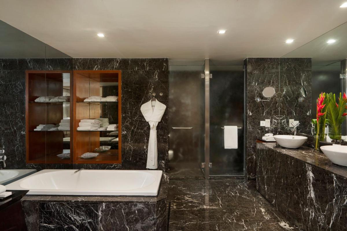 a bathroom with a tub and a glass shower at InterContinental Marine Drive Mumbai by IHG in Mumbai