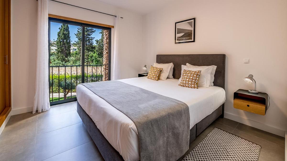 um quarto com uma cama grande e uma janela grande em Estrela da Luz Resort na Praia da Luz