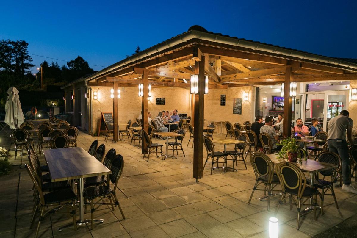 un groupe de personnes assises à des tables dans un patio dans l'établissement Le Clos des Bruyères, à Vallon-Pont-dʼArc