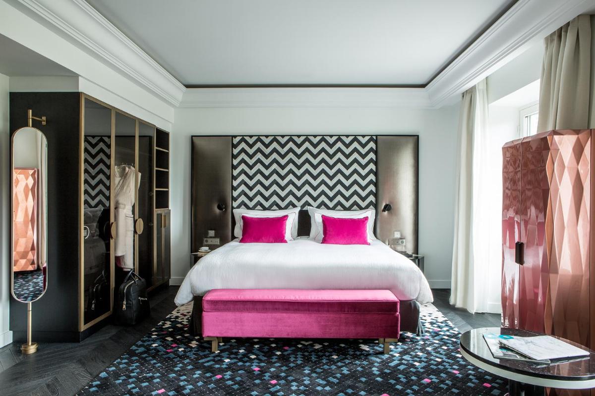 une chambre avec un grand lit avec des oreillers roses dans l'établissement Fauchon l'Hôtel Paris, à Paris