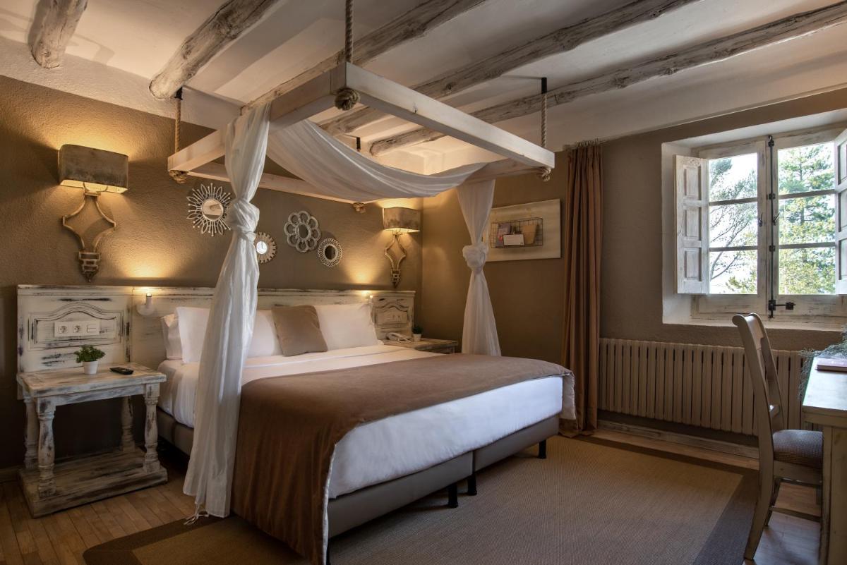 1 dormitorio con cama con dosel y mesa en Hotel Luze El Toro, en Berrioplano
