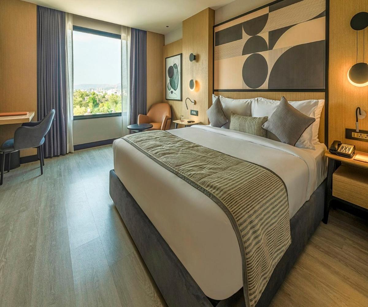 a hotel room with a large bed and a window at Parallel Hotel Udaipur, a member of Radisson Individuals in Udaipur