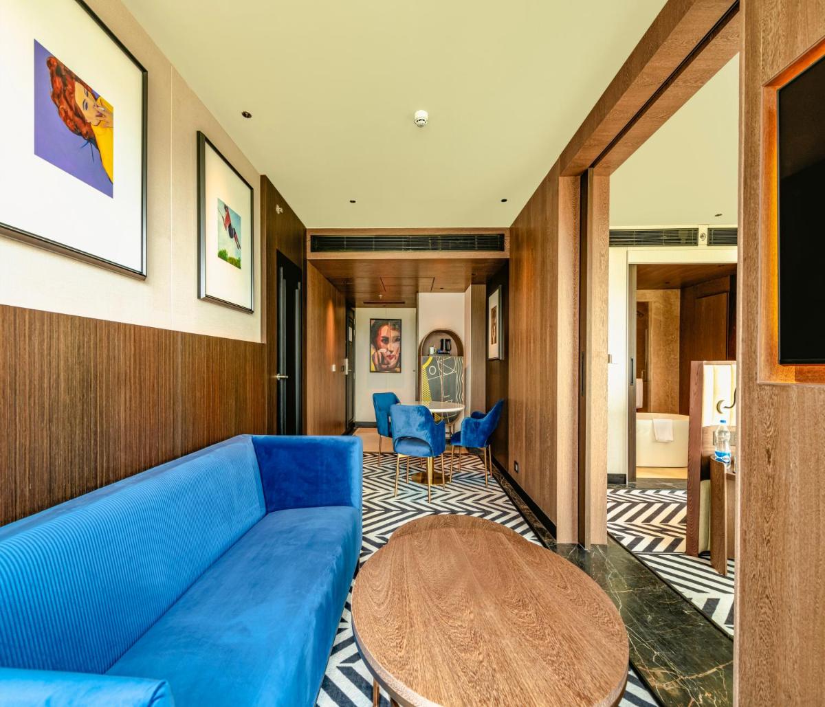 a living room with a blue couch and a table at Parallel Hotel Udaipur, a member of Radisson Individuals in Udaipur
