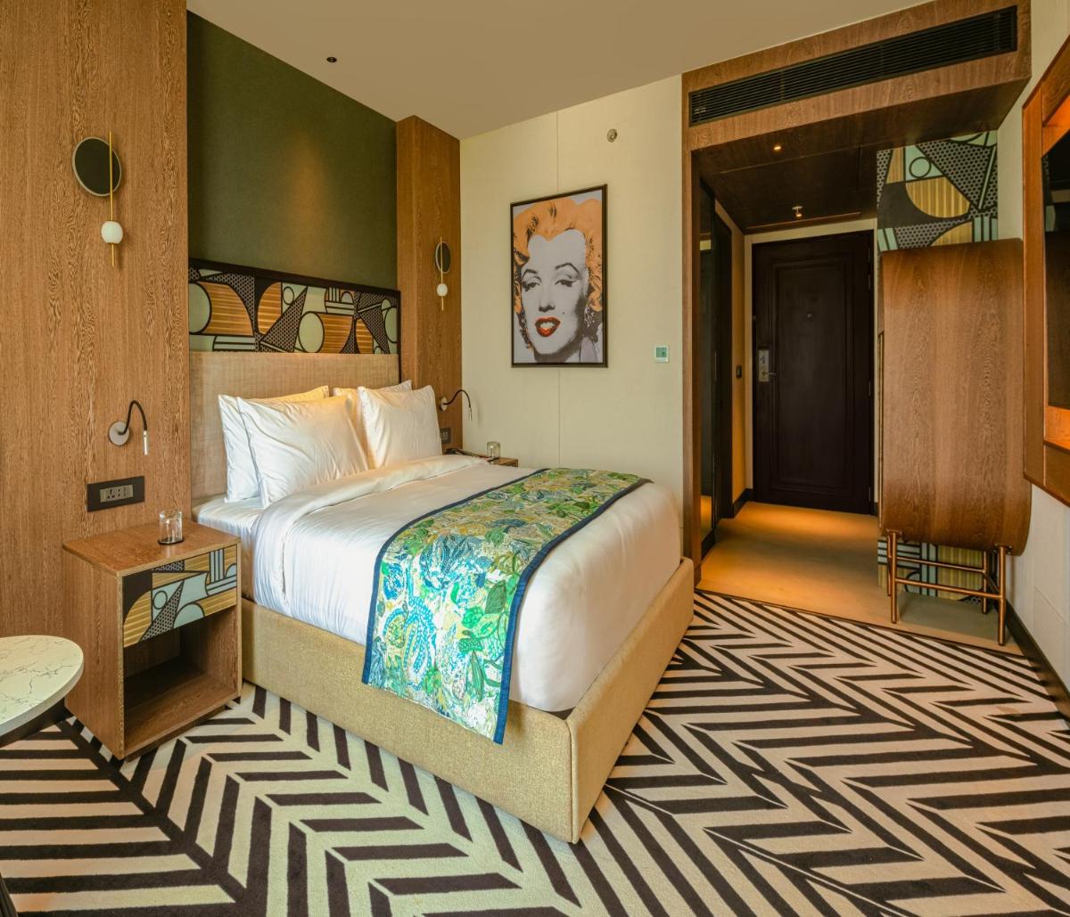 a hotel room with a bed and a hallway at Parallel Hotel Udaipur, a member of Radisson Individuals in Udaipur