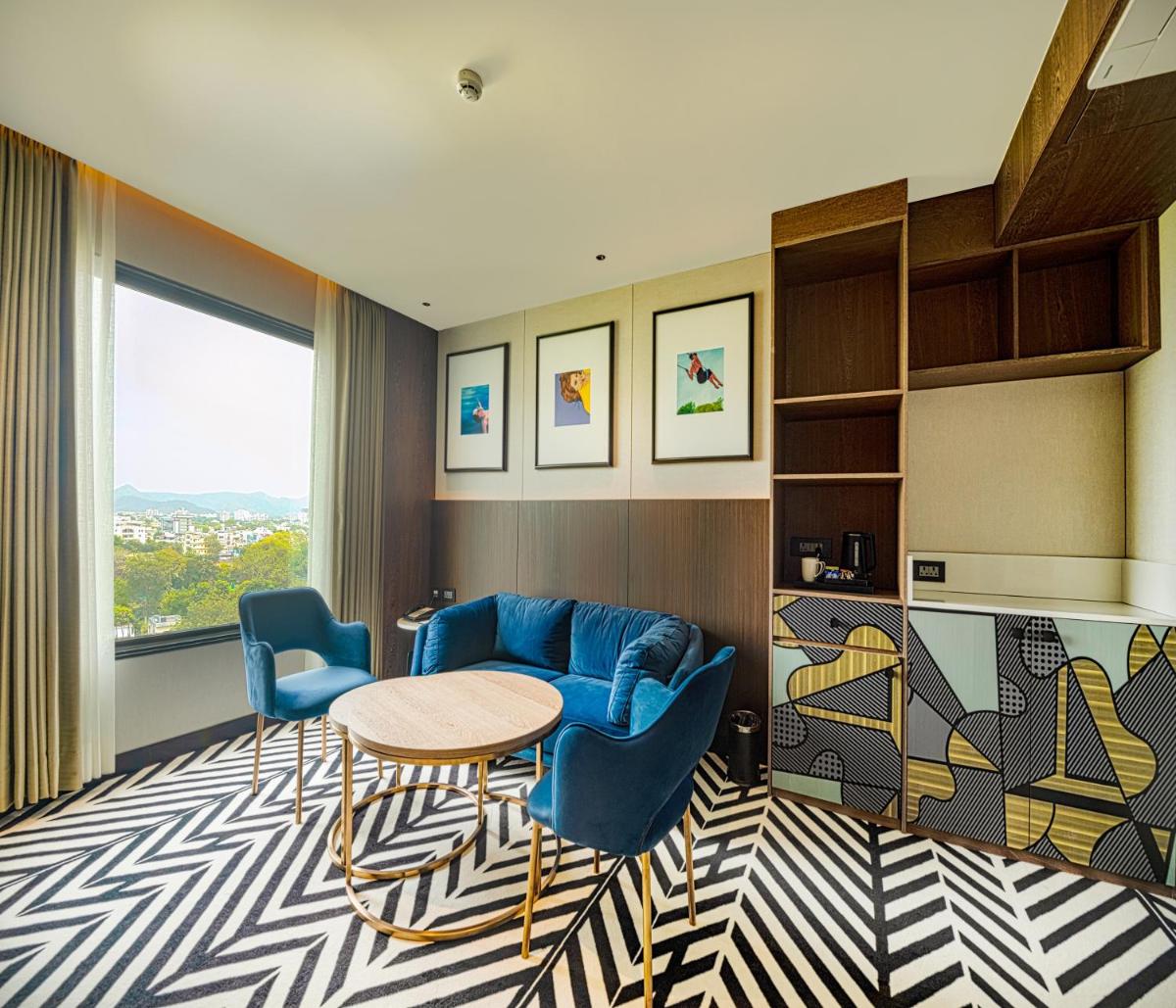 a living room with a blue couch and a table at Parallel Hotel Udaipur, a member of Radisson Individuals in Udaipur