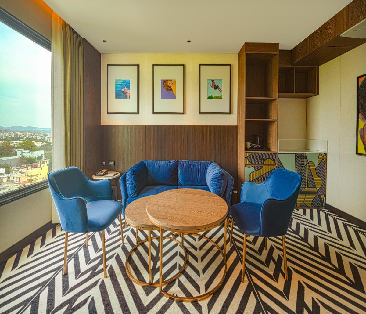 a room with a table and two blue chairs at Parallel Hotel Udaipur, a member of Radisson Individuals in Udaipur