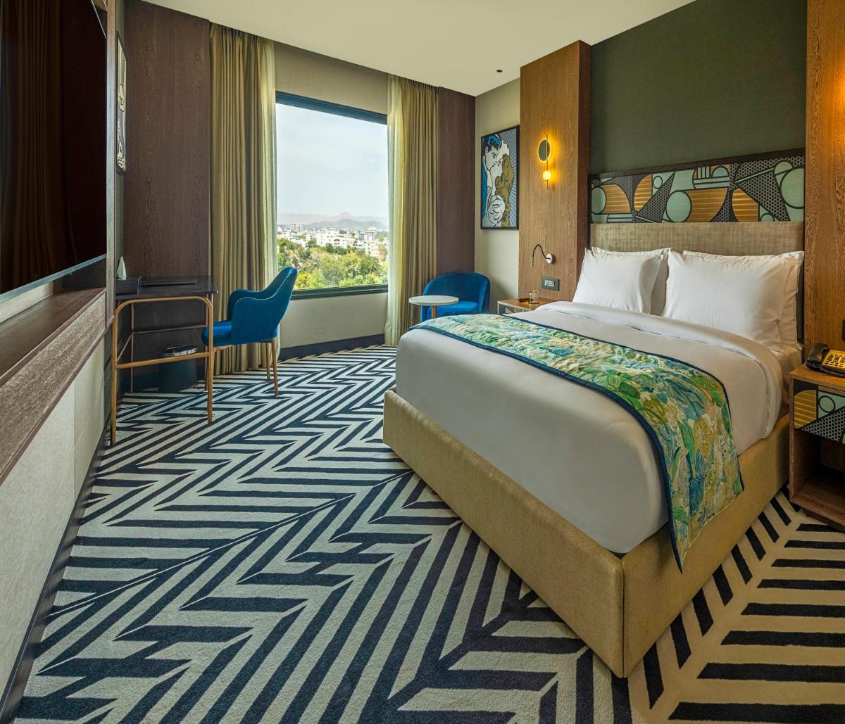 a hotel room with a large bed and a window at Parallel Hotel Udaipur, a member of Radisson Individuals in Udaipur