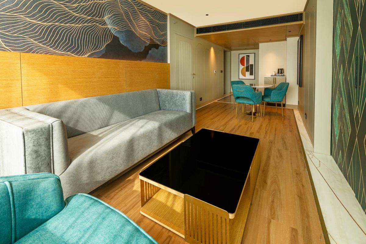 a living room with a couch and blue chairs at Parallel Hotel Udaipur, a member of Radisson Individuals in Udaipur