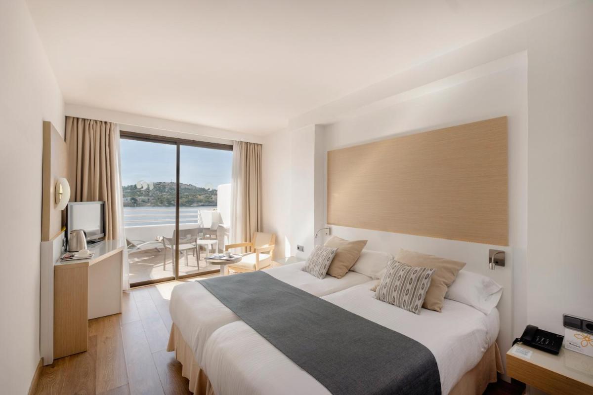 Una habitación de hotel con una cama grande y una ventana grande. en Sentido Fido Punta del Mar Hotel & Spa - Adults Only, en Santa Ponsa 91 fotos más