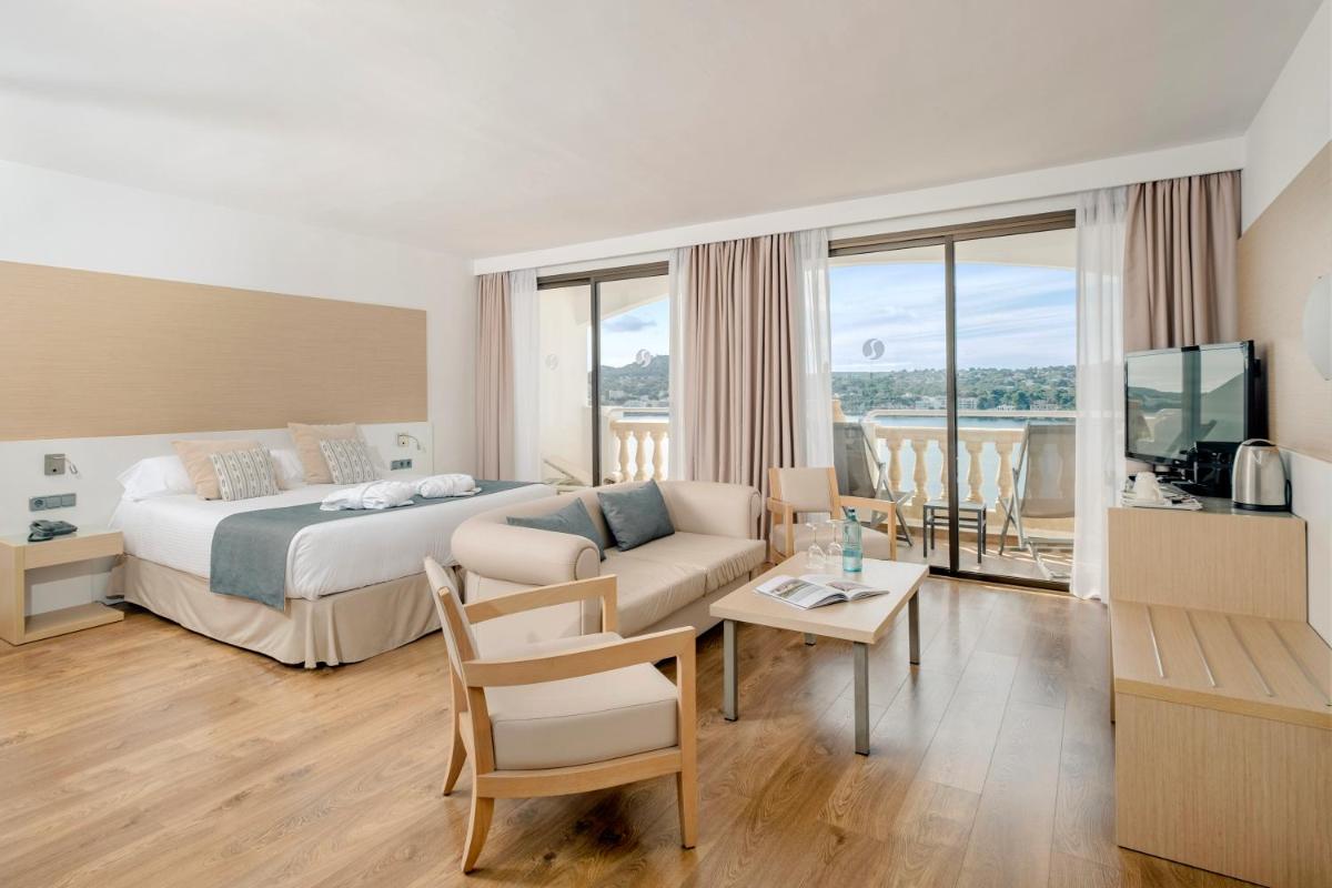 una habitación de hotel con una cama y un sofá en Sentido Fido Punta del Mar Hotel & Spa - Adults Only, en Santa Ponsa