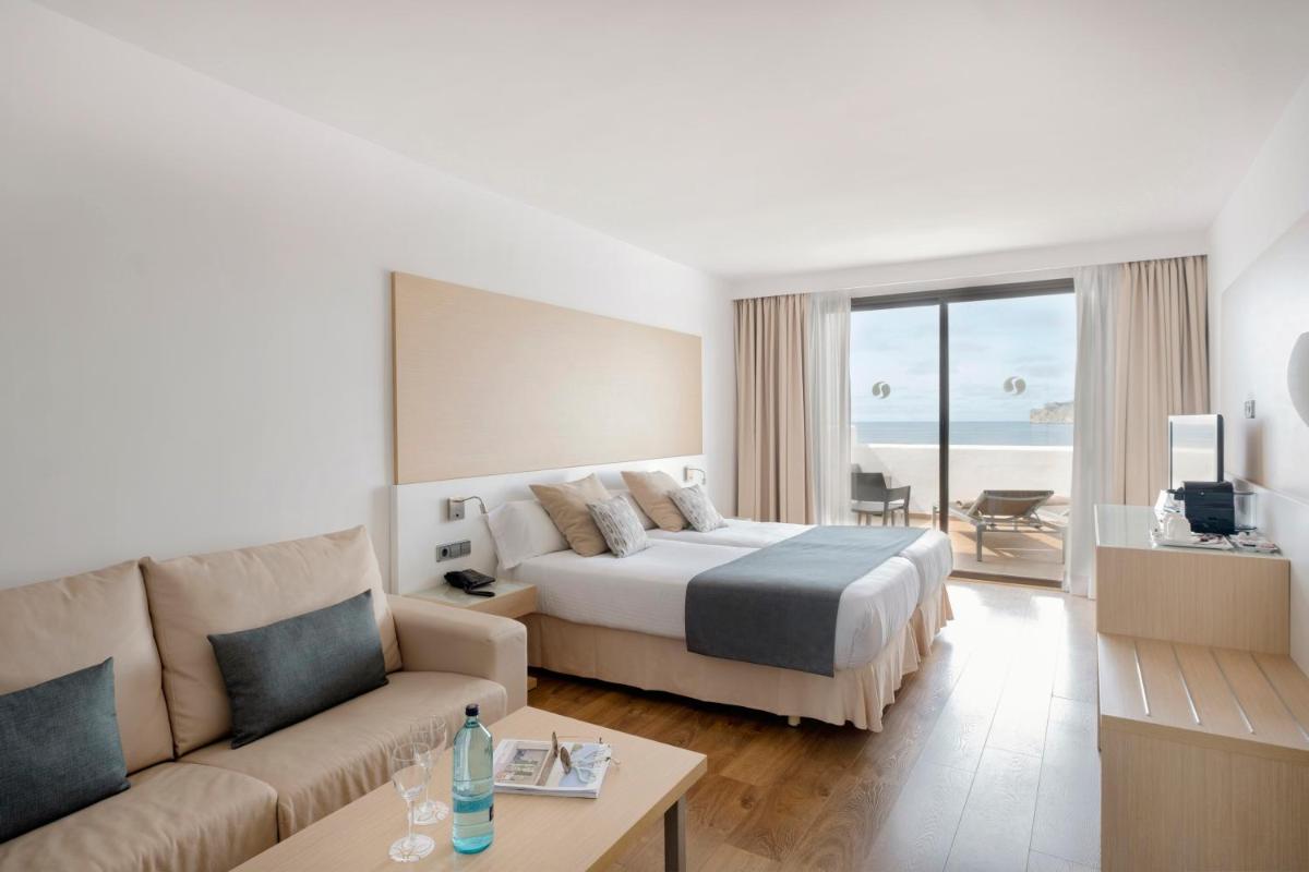 una habitación de hotel con una cama y un sofá en Sentido Fido Punta del Mar Hotel & Spa - Adults Only, en Santa Ponsa