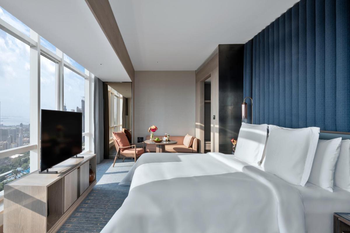 a hotel room with a large bed and a large window at Four Seasons Hotel Mumbai in Mumbai