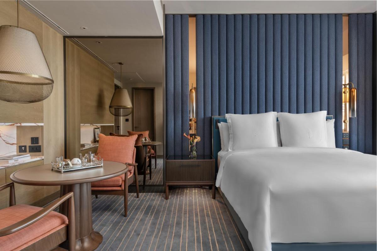 a hotel room with a large bed and a table at Four Seasons Hotel Mumbai in Mumbai