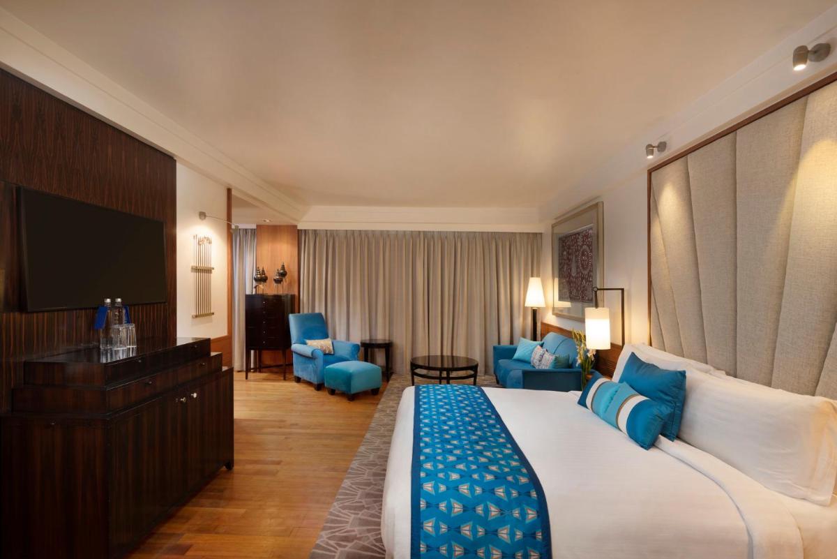 a hotel room with a large bed and a television at InterContinental Marine Drive Mumbai by IHG in Mumbai