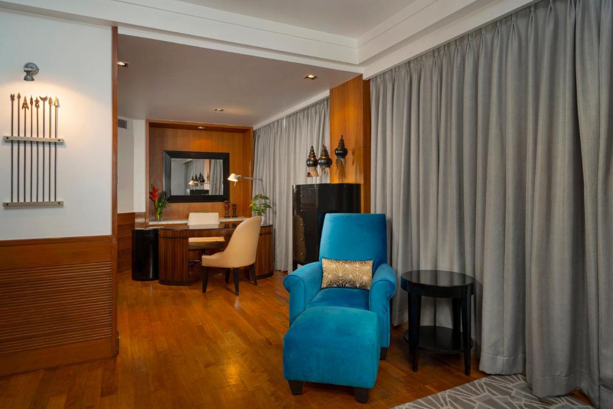 a living room with a blue chair and a table at InterContinental Marine Drive Mumbai by IHG in Mumbai