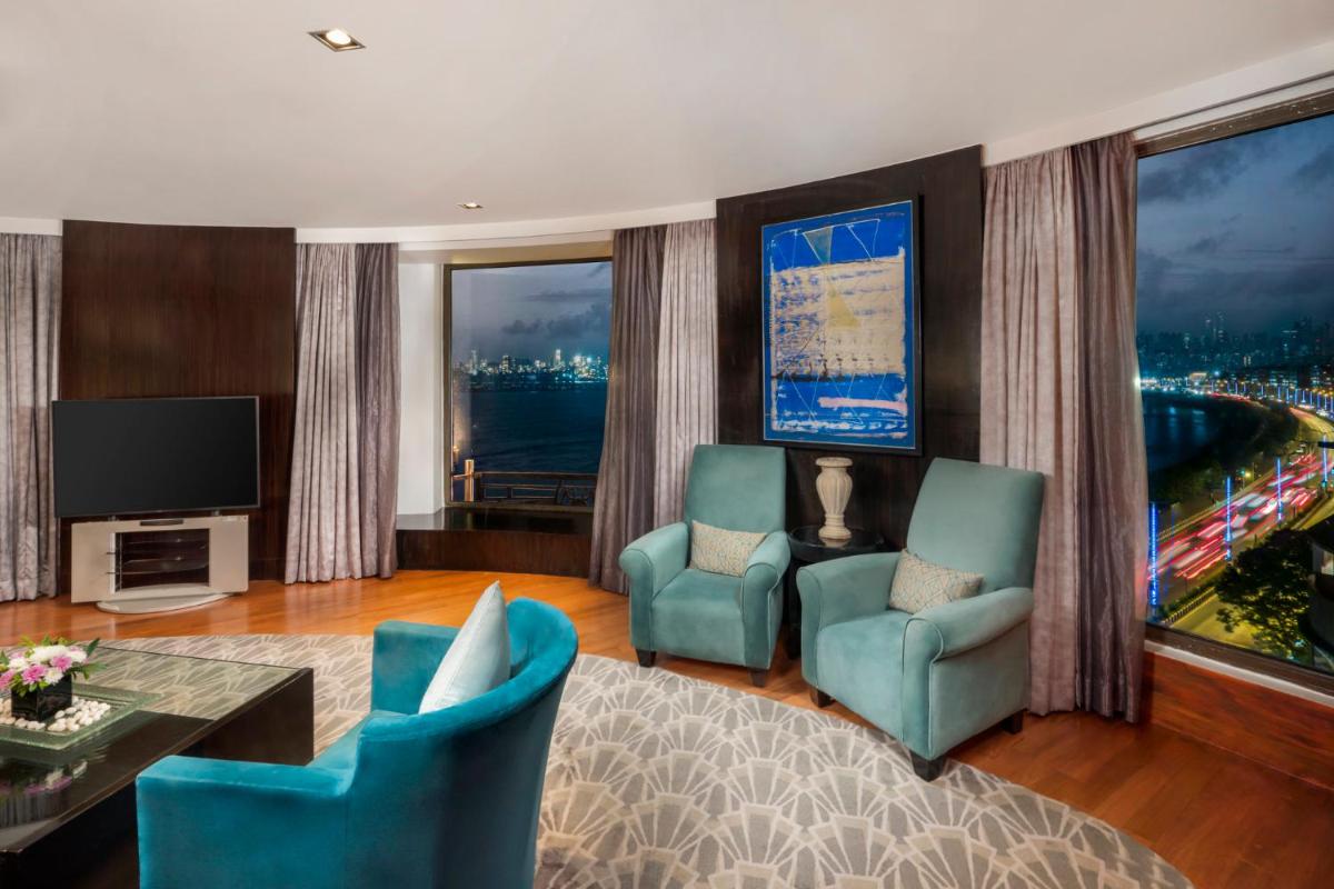 a living room with two chairs and a television at InterContinental Marine Drive Mumbai by IHG in Mumbai