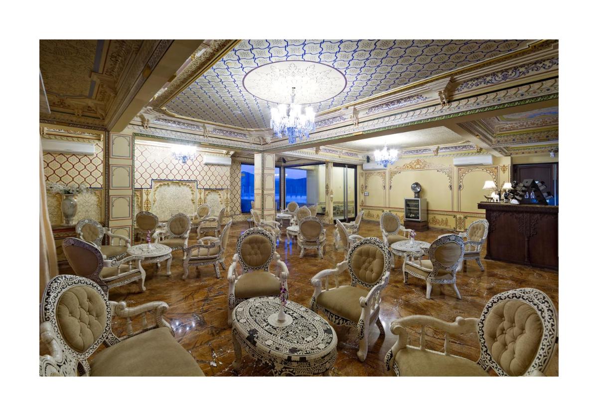 a large room with chairs and tables and a chandelier at Chunda Palace in Udaipur