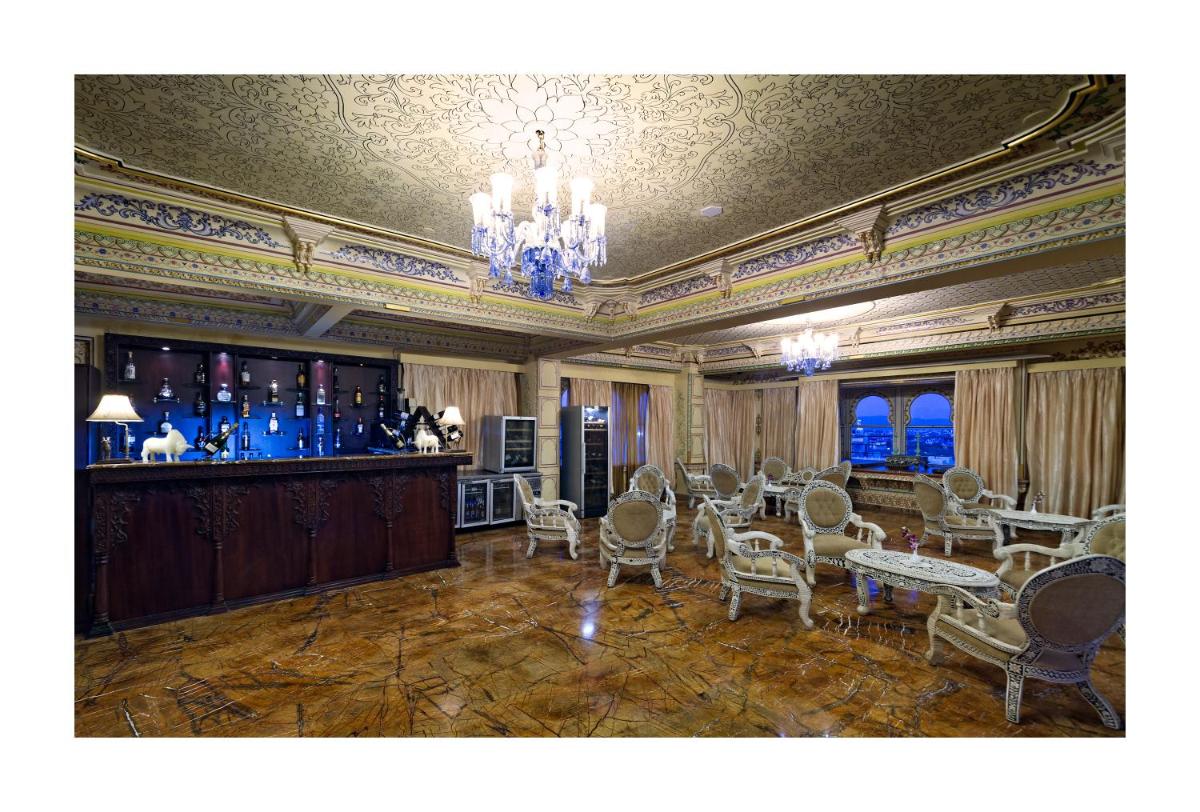 a room with a bar with chairs and a table at Chunda Palace in Udaipur