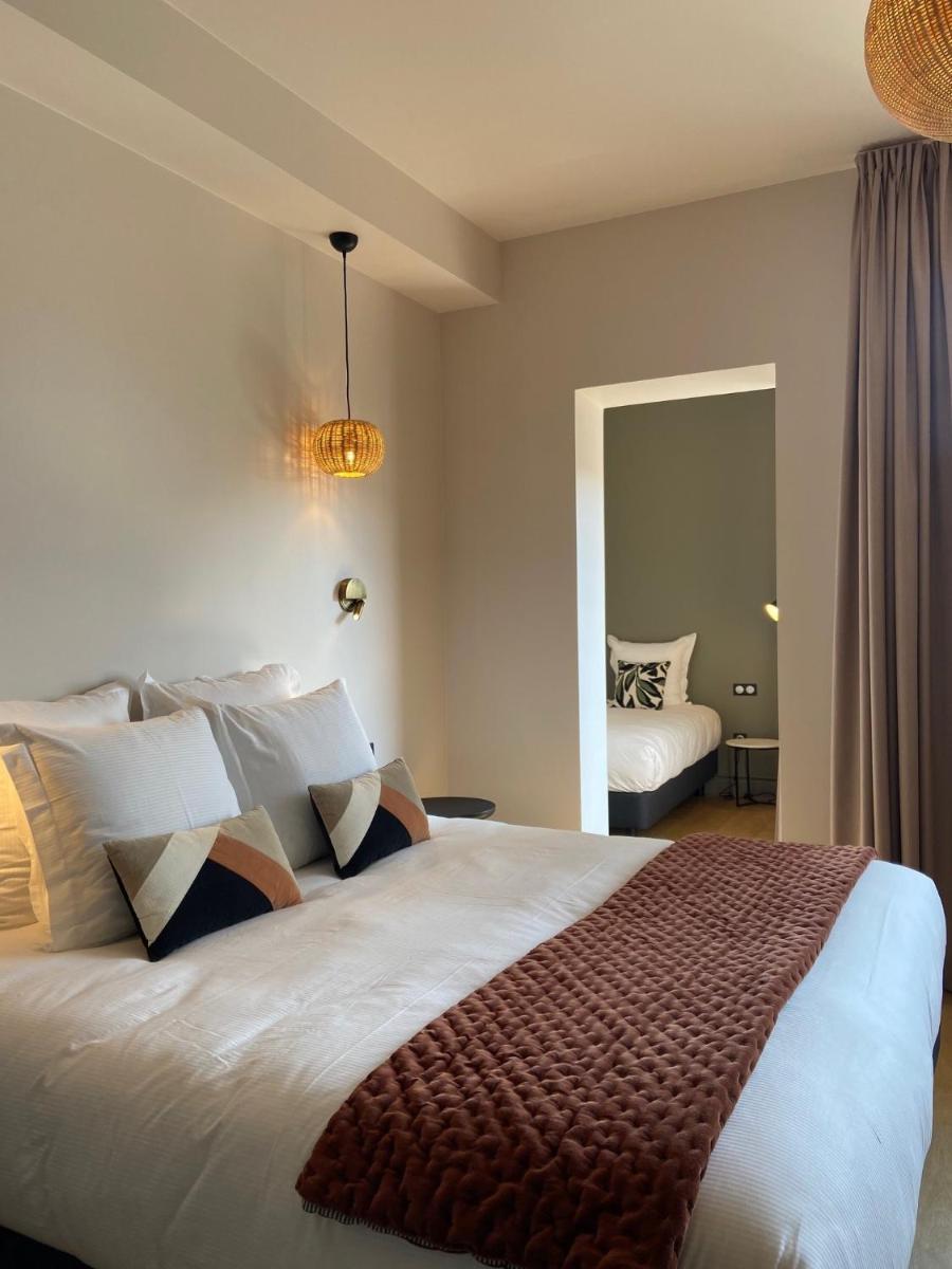 Un ou plusieurs lits dans un hébergement de l'établissement L'INVITATION AU VOYAGE - Hôtel & Spa