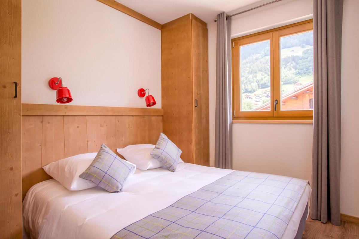une chambre avec un lit blanc avec une fenêtre dans l'établissement Résidence Club MMV La Clé des Cimes, à Arêches 44 autres photos