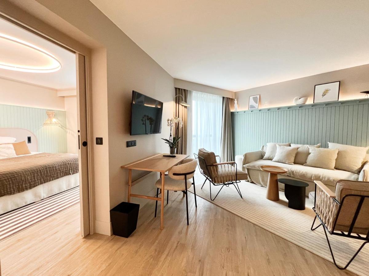une chambre d'hôtel avec un lit, un canapé et une table dans l'établissement Emeria Dinard Thalasso Spa, à Dinard