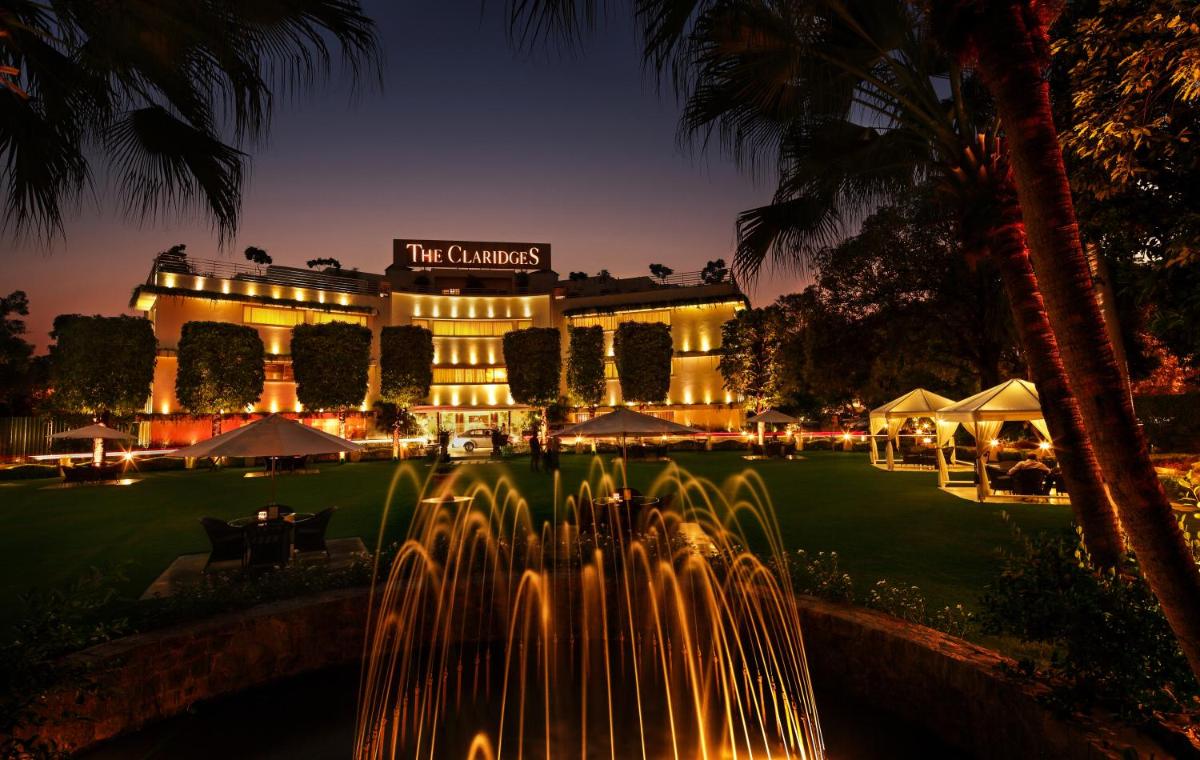 a building with a fountain in front of it at night at The Claridges New Delhi in New Delhi a building with a fountain in front of it at night at The Claridges New Delhi in New Delhi