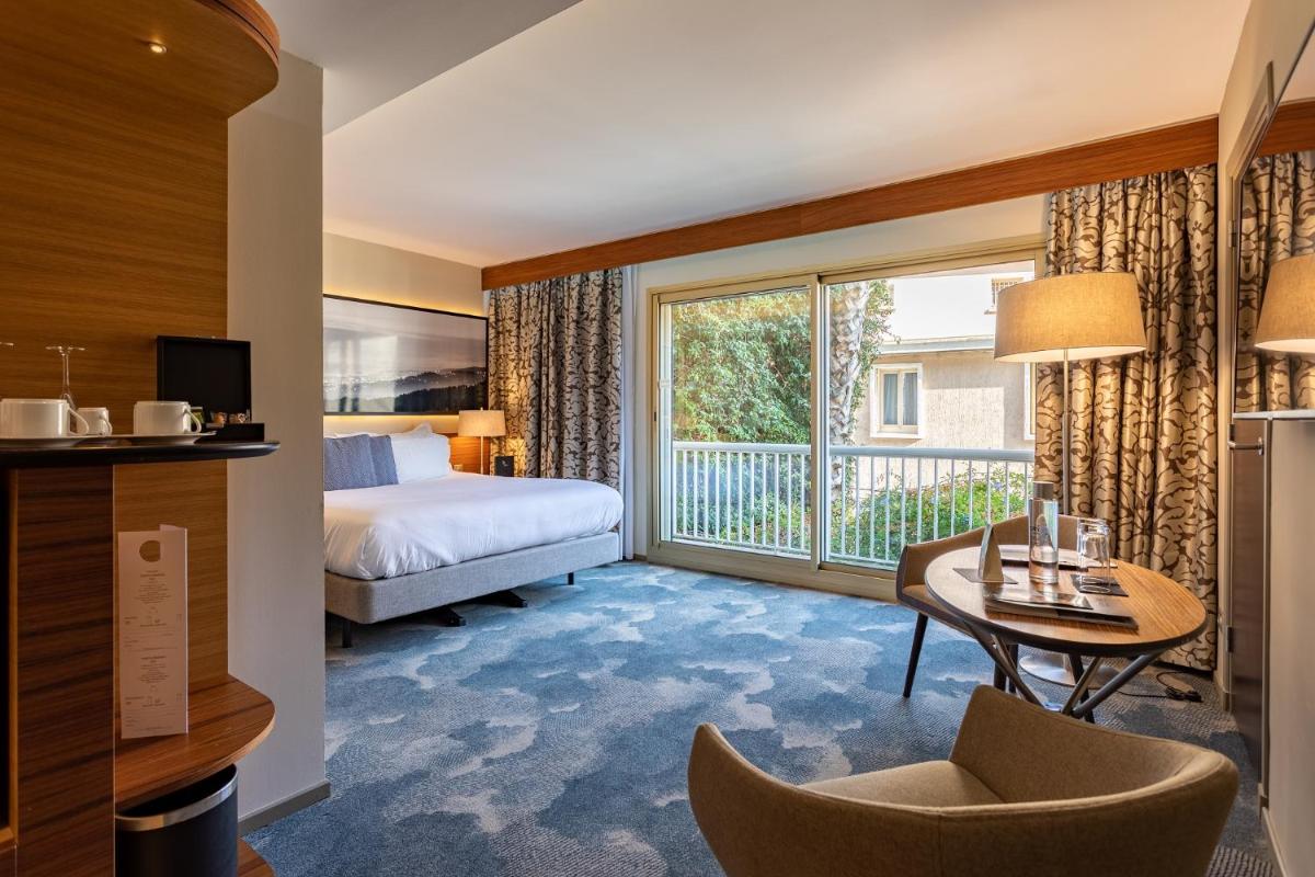 une chambre d'hôtel avec un lit et une grande fenêtre dans l'établissement Thalazur Bandol Ile Rousse - Hôtel & Spa, à Bandol 37 autres photos