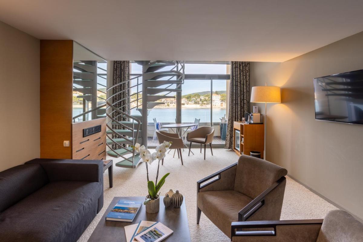 un salon avec un canapé, des chaises et une table dans l'établissement Thalazur Bandol Ile Rousse - Hôtel & Spa, à Bandol