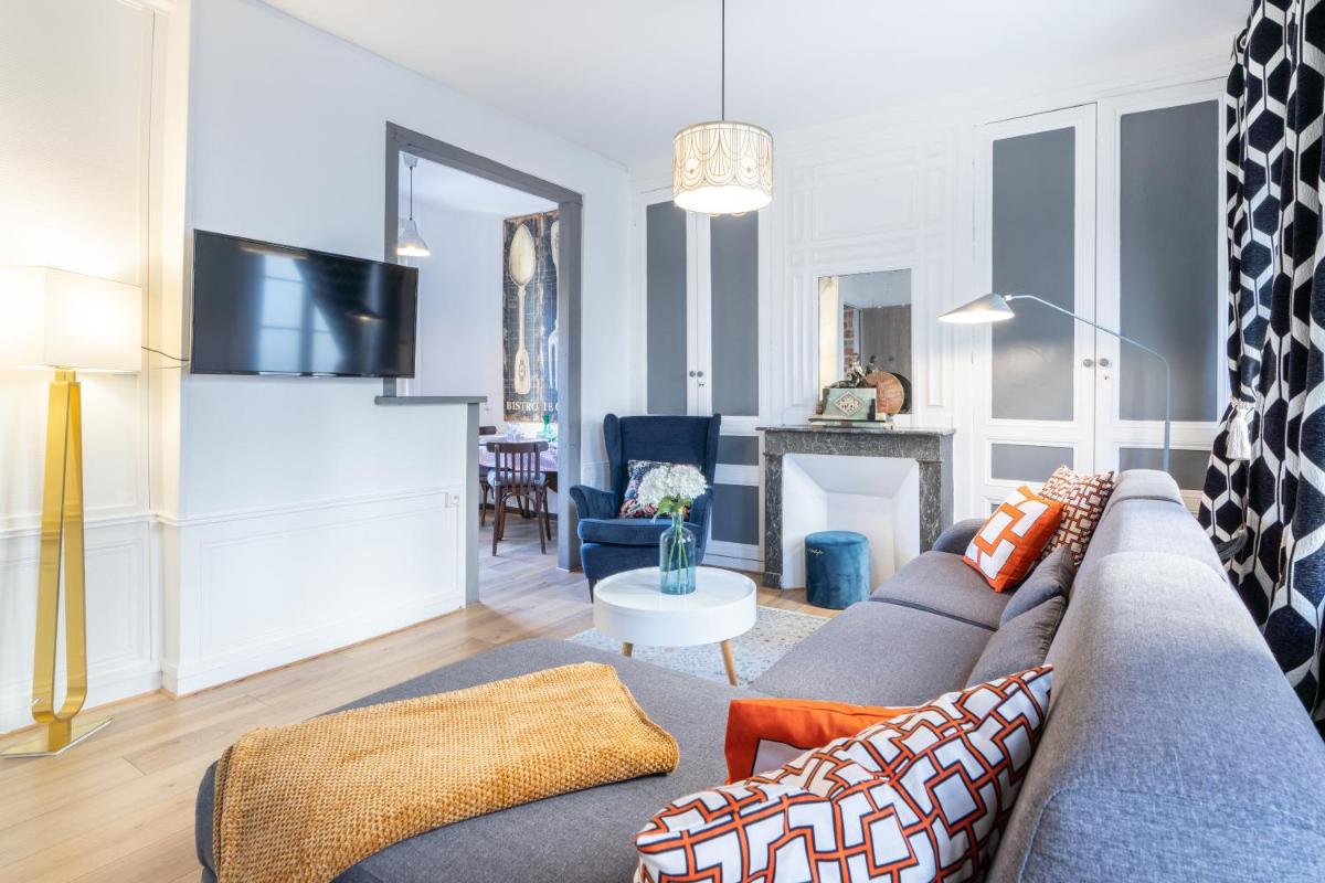 un salon avec un canapé et une table dans l'établissement TOWNHOUSE TROUVILLE - Appart'Hotel & Studios, à Trouville-sur-Mer