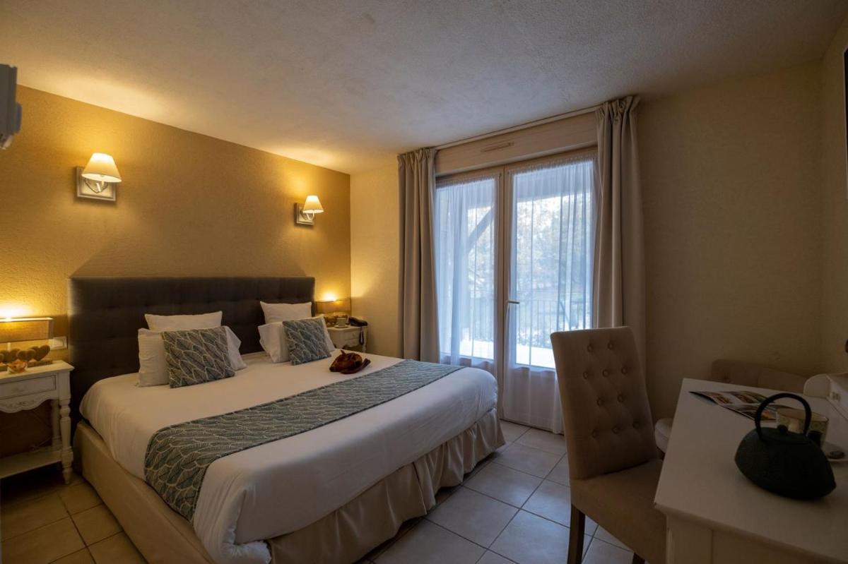 Un ou plusieurs lits dans un hébergement de l'établissement Le Belvédère Hotel et Bien être