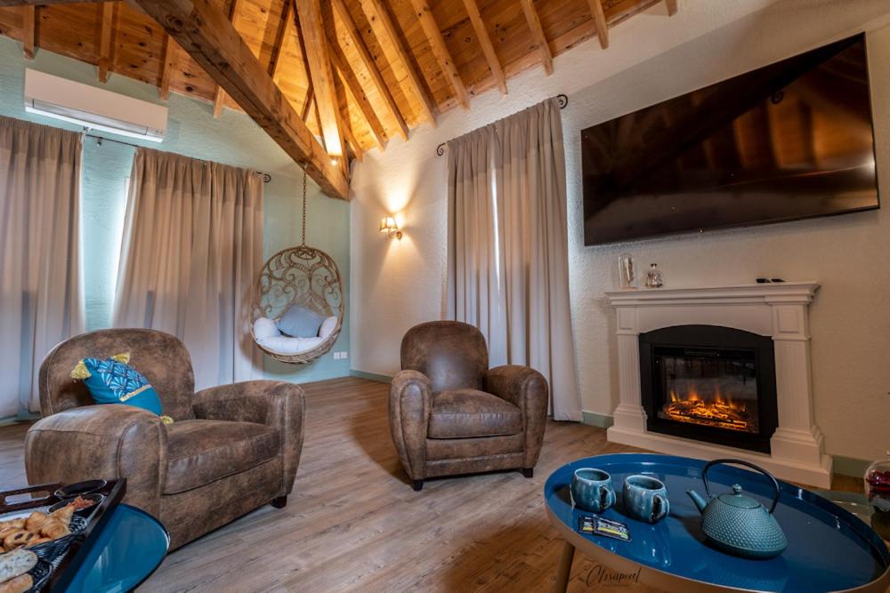 un salon avec deux fauteuils et une cheminée dans l'établissement Le Belvédère Hotel et Bien être, à Lauzerte