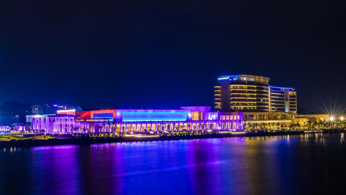 a building lit up in purple and blue at night at Grand Hyatt Kochi Bolgatty in Cochin