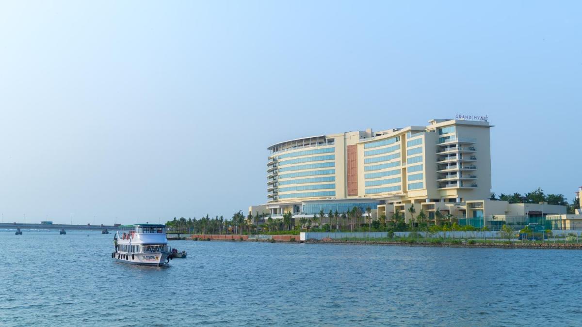 a boat in the water in front of a large building at Grand Hyatt Kochi Bolgatty in Cochin