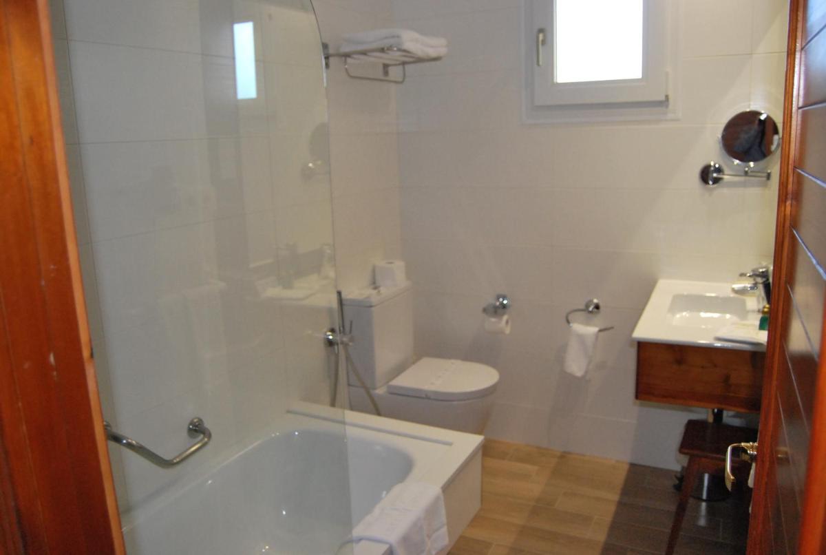 Un baño con bañera, inodoro y lavabo. en Hotel Spa Bosque mar, en Reboredo 78 fotos más