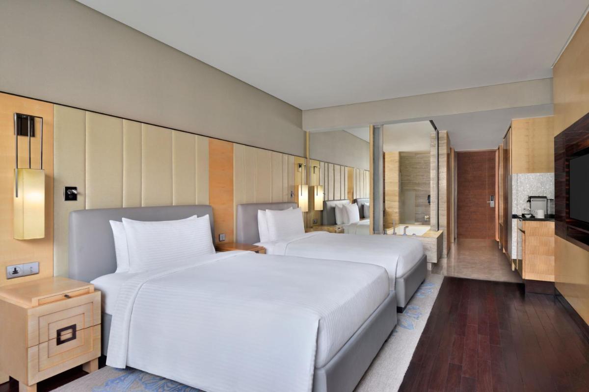 a large white bed in a hotel room at JW Marriott Hotel New Delhi Aerocity in New Delhi a large white bed in a hotel room at JW Marriott Hotel New Delhi Aerocity in New Delhi