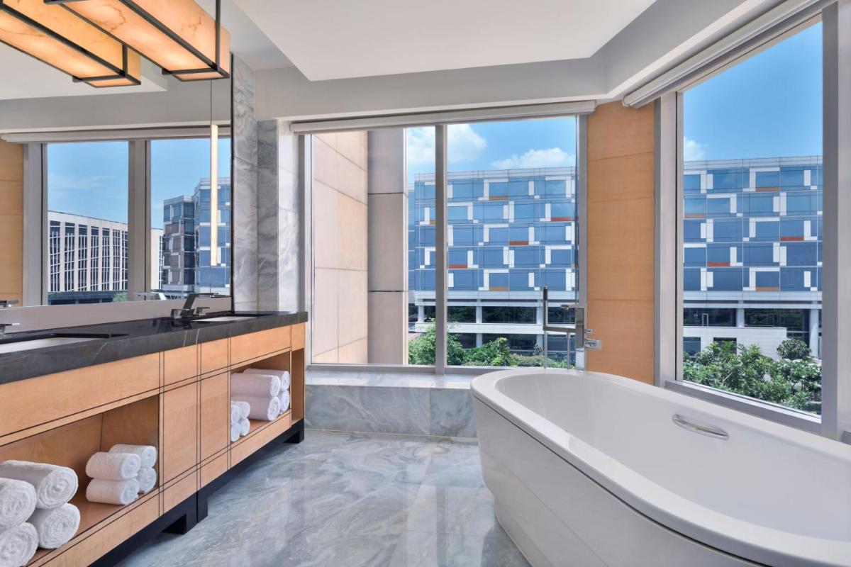 a bathroom with a tub and large windows at JW Marriott Hotel New Delhi Aerocity in New Delhi a bathroom with a tub and large windows at JW Marriott Hotel New Delhi Aerocity in New Delhi