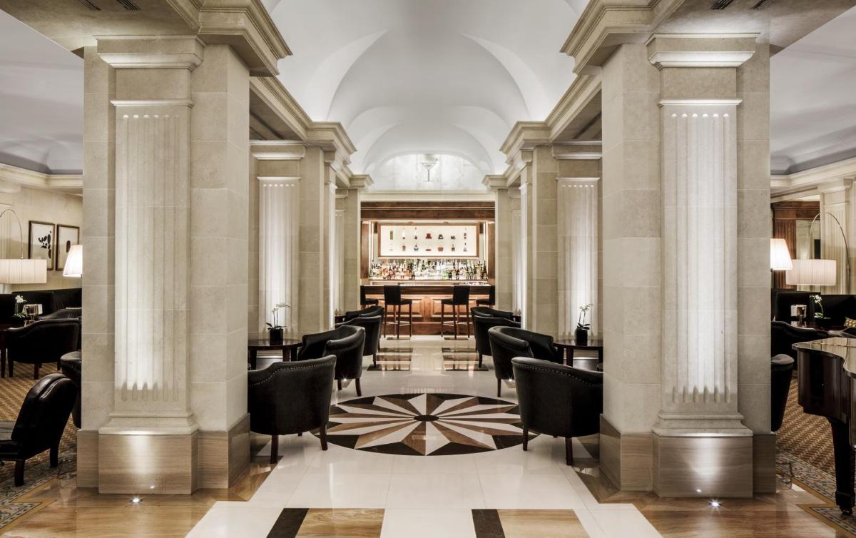 Un bar con sillas y mesas en un edificio. en Majestic Hotel & Spa Barcelona GL, en Barcelona