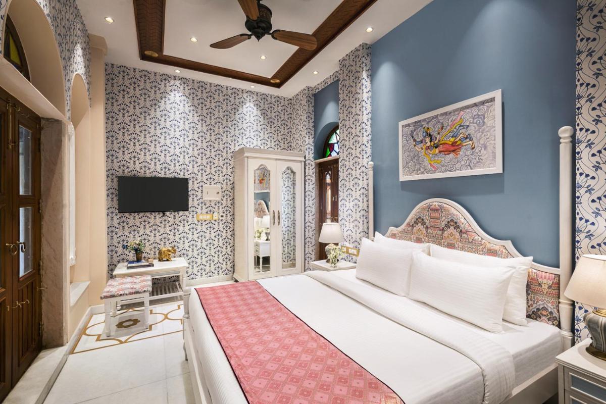 a bedroom with a bed and a tv at Haveli Dharampura & Golden Haveli- UNESCO awarded Boutique Heritage Hotel in New Delhi a bedroom with a bed and a tv at Haveli Dharampura & Golden Haveli- UNESCO awarded Boutique Heritage Hotel in New Delhi
