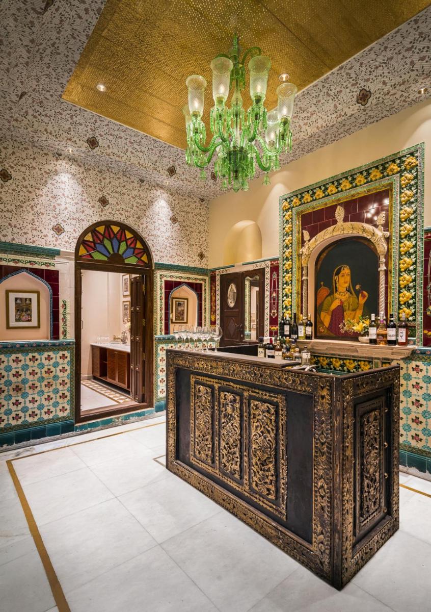 a room with a counter with a painting and a chandelier at Haveli Dharampura & Golden Haveli- UNESCO awarded Boutique Heritage Hotel in New Delhi a room with a counter with a painting and a chandelier at Haveli Dharampura & Golden Haveli- UNESCO awarded Boutique Heritage Hotel in New Delhi